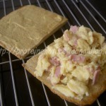 Sandwich grillé avec des oeufs brouillés et jambon